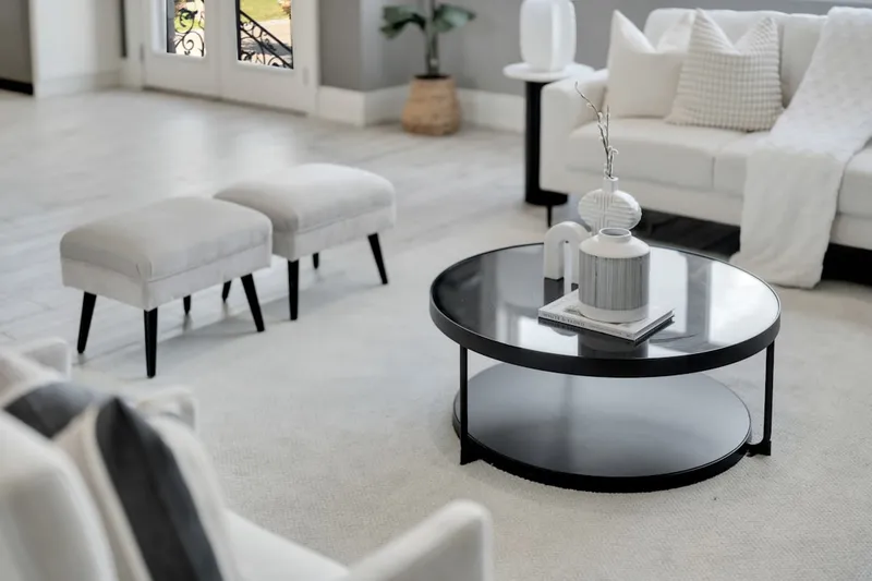 Modern living room with white sofa and round coffee table.